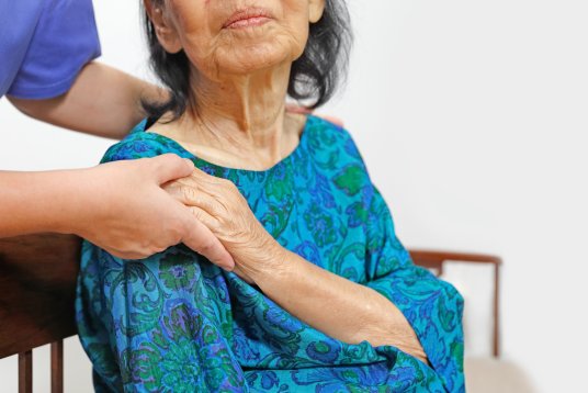 Mujer agarra la mano a anciana